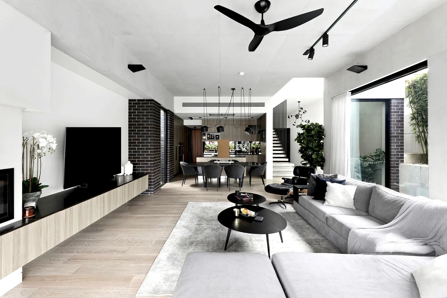 Contemporary open-plan living and dining with modern furniture and feature lighting.